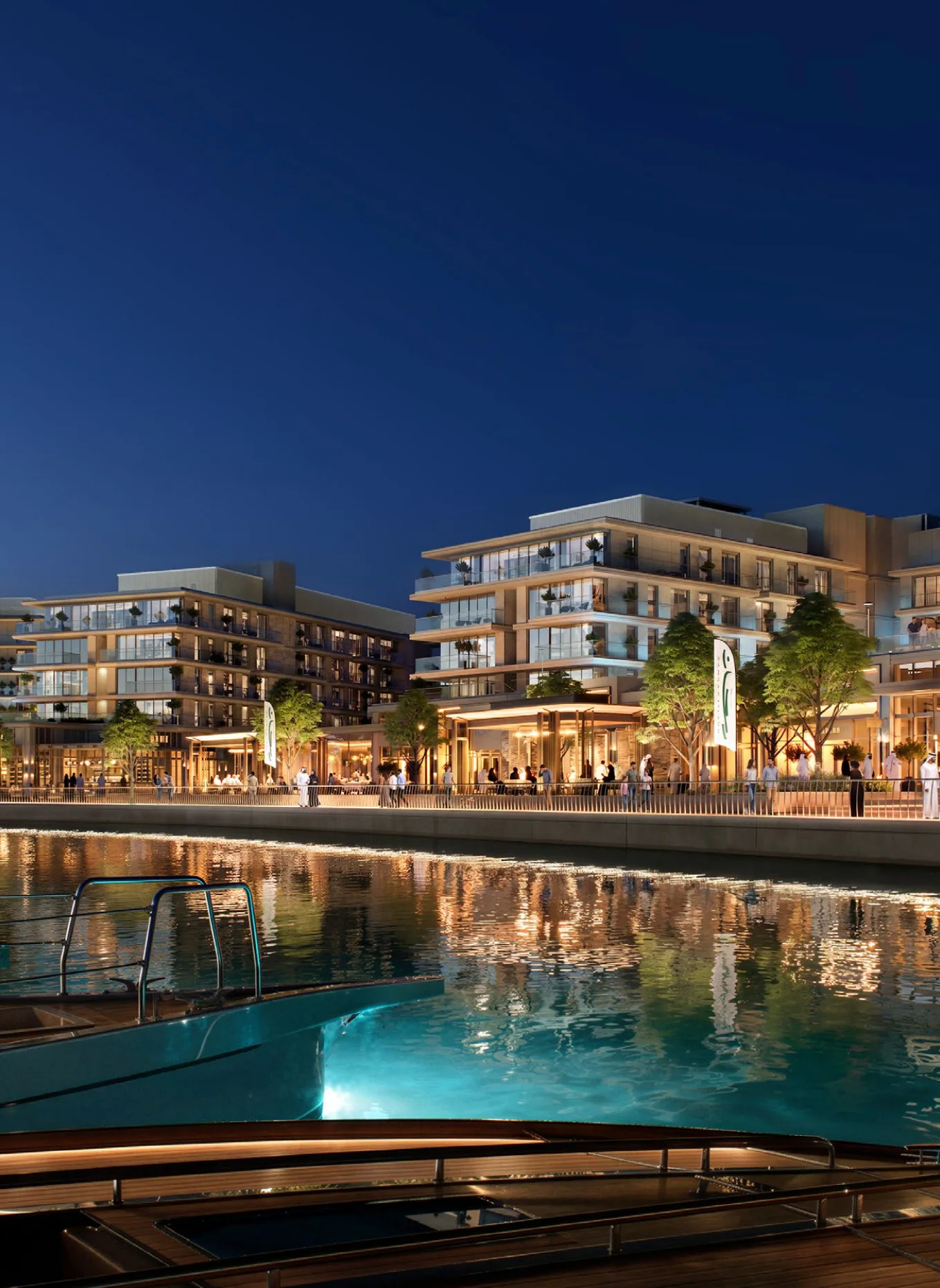 The promenade at dusk, with waterside dining and glowing storefronts at Ramhan Marina
